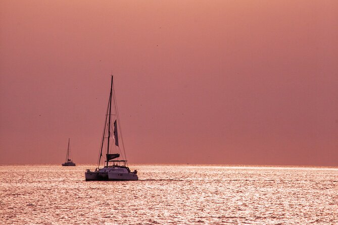 Deluxe Santorini Sailing with BBQ and Drinks Shared Tour - Red Beach, White Beach, and the lighthouse pass that makes the coast click