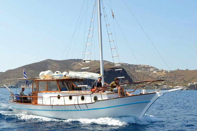 Santorini Caldera Sunset Traditional Cruise with Meal and Drinks - Akrotiri lighthouse sailing past: old-world coastline at the edge of the cliff